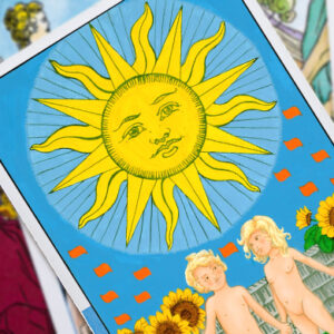 A tarot card depicting the Sun, with a radiant, stylized sun at the top. Below, two children play joyfully in a garden with sunflowers. The background is a bright blue sky with red banners.