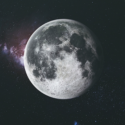 A detailed view of the moon against a starry background in space, with visible craters and surface textures, and a faint purple nebula to the left.