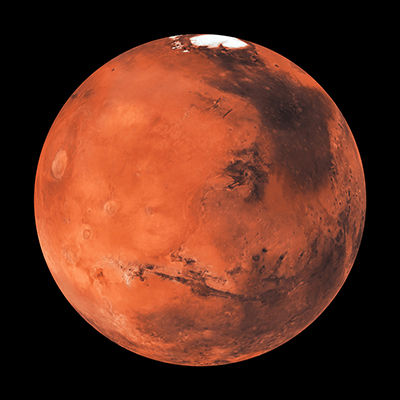 A detailed image of the planet Mars showing its reddish surface, dark markings, craters, and a white polar ice cap near the top, set against a black background.